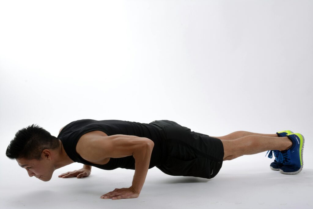 Young man in athletic wear doing push-ups, showcasing strength and fitness.